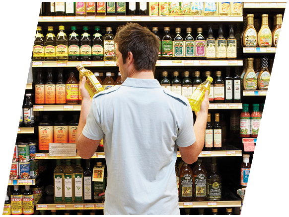 Young man in supermarket comparing bottles of oil, rear view, close-up