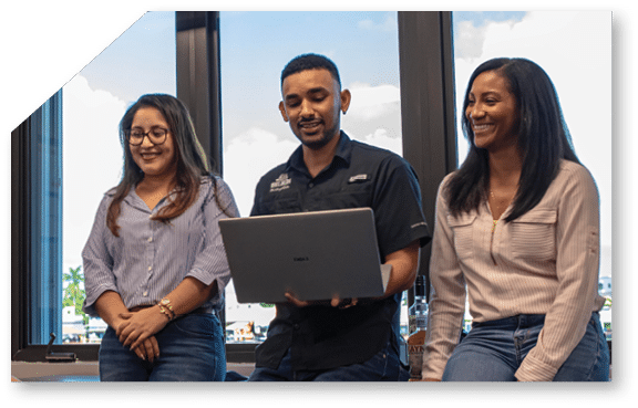 A man and three women are standing around a table. Description generated by AI