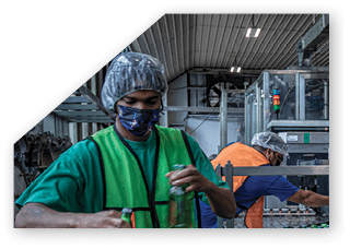 A man wearing a green vest is holding a green crate. Description generated by AI